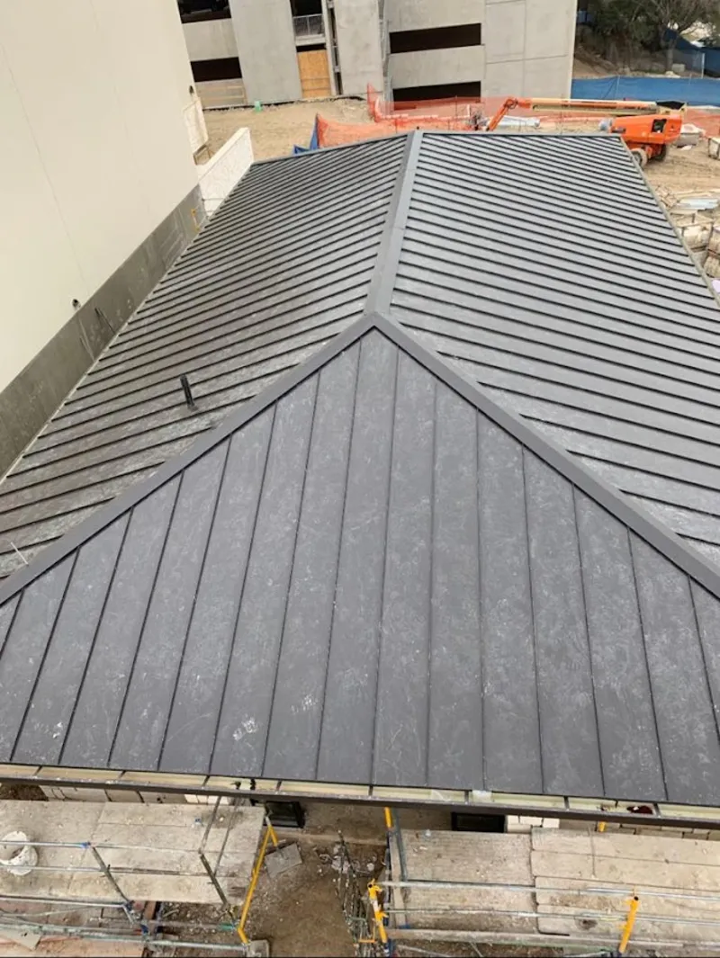 Commercial metal roof construction with crane equipment in Post Falls